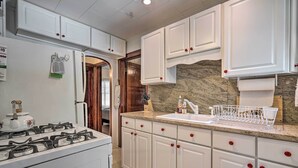 A kitchen with white cabinets, a granite countertop, and a gas stove. - Dog-Friendly Waretown Home w/ Furnished Deck! (Waretown)