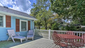 A wooden deck with a table and chairs, a white railing, and a house with blue siding and brown shutters. - Dog-Friendly Waretown Home w/ Furnished Deck! (Waretown)
