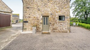 A stone building with a door and a small window, labeled "The Granary."
