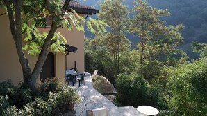 A patio area with a table and chairs, a drying rack, and a view of a mountainous landscape. - 2 Bed Flat - Pets - Pool - Garden - Parking (Borgo Val di Taro)