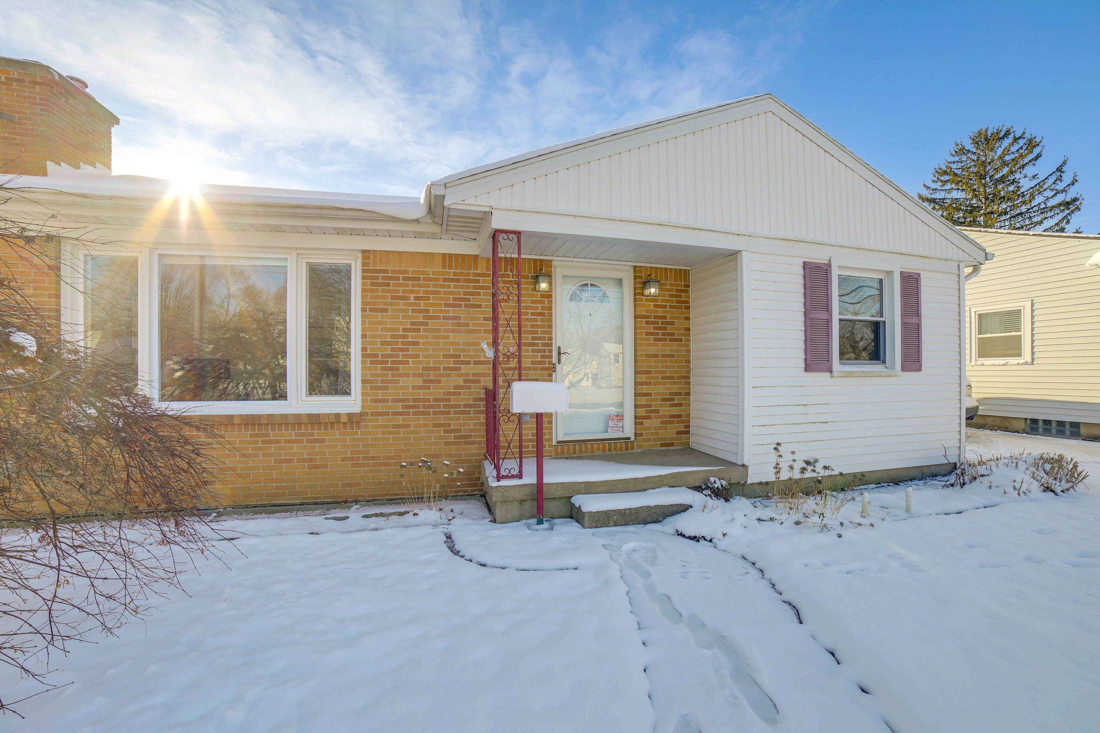 A single-story house with a brick facade and a white exterior.