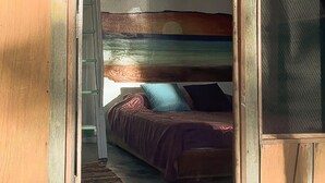 A room with a bed, a window, and a door. - Surrounded By Trees In Front Of The Sea (Cóbano)