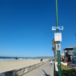 A beachside promenade with a speed limit sign of 8 MPH, a street sign for CT 700, and a sign indicating regulations for beach access. - Best Court South Mission Beach! Steps to Beach & Bay w/ Parking, Bikes & Jacuzzi (San Diego)