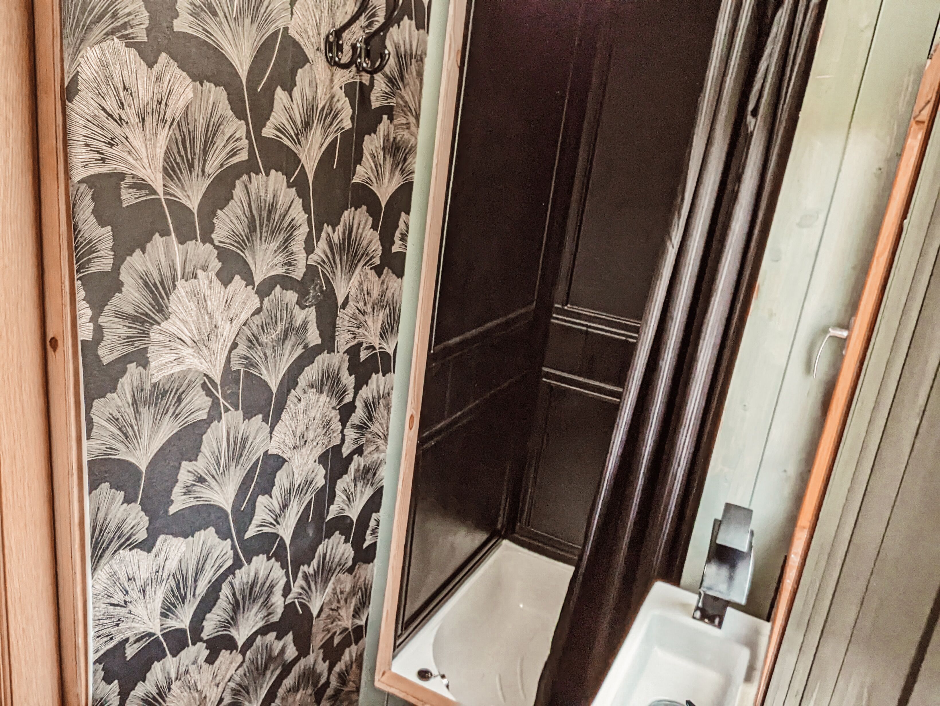 A bathroom with a shower, a sink, and a mirror.
