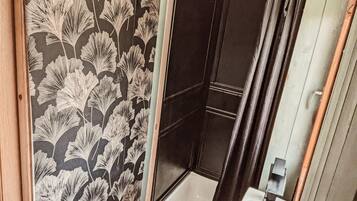 A bathroom with a shower, a sink, and a mirror.