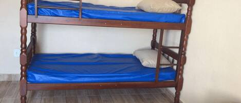 A bunk bed with blue bedding and a wooden frame.