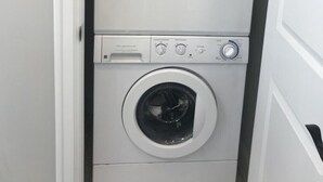 A compact, two-door laundry machine in a narrow space. - Guest Apartment close to Ski Resorts, Hiking Trails, Shopping Restaurants & more (Holladay)