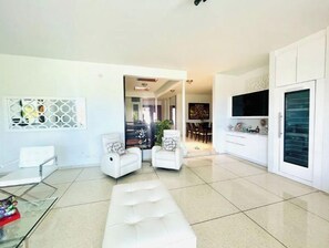 A modern living room with a sofa, chairs, a glass coffee table, and a dining area with chairs and a table. - Mansion Laura - a master room for everyone. (Guaynabo)