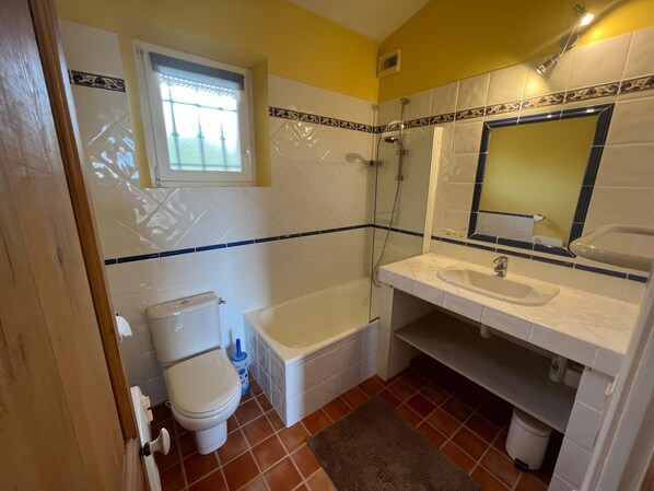 Une salle de bain comprenant des toilettes, une baignoire et un lavabo.