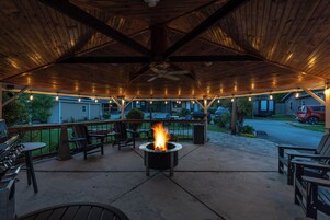 Un patio exterior con una chimenea, asientos y vistas del vecindario.