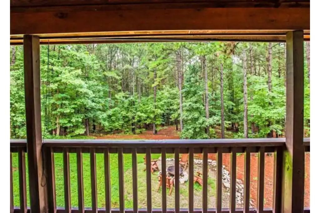 A wooden deck with a view of a forested area.