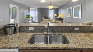A modern kitchen with granite countertops, stainless steel sink, and pendant lighting. - 11TH FLOOR OCEAN VIEW 3 BEDROOM WITH RESORT ACCESS | UNIT 1107 (North Myrtle Beach)