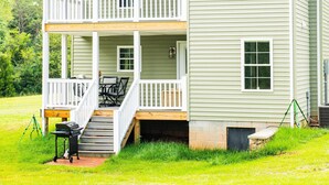 A two-story house with a front porch, a covered deck, and a small outdoor seating area. - JULY DISCOUNT! Romantic 2 BR 2 story w/mountain views and stunning outdoor space (Amherst)