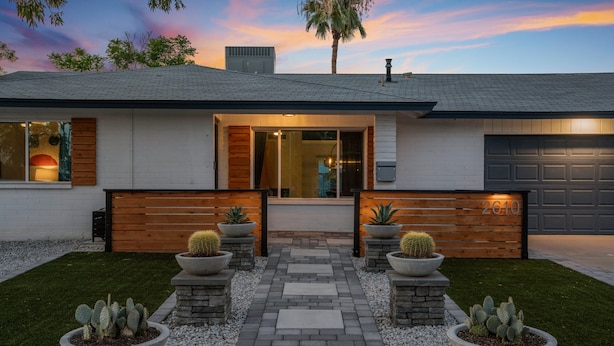A modern house with a garage, a driveway, and a well-maintained lawn.