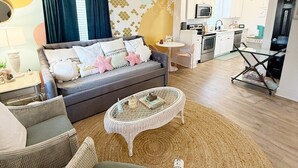 Un saló modern amb sofà, taula de centre i zona de menjador, amb cuina al fons.