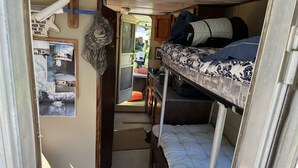 A compact RV interior with bunk beds, a small kitchenette, and a door leading outside. - Get off the grid in south La (Bayou Vista)