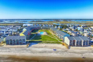 A coastal resort with multiple-story buildings, a central pool, and a beach area. - Saltwater Haven - Beach Front, Ocean View (Surf City)