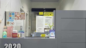 A reception desk at the 2020 Travelers Inn with a sign indicating accepted payment methods, a tax map, and a notice about lost hotel cards. - 2020 Travelers Inn (Dumaguete)