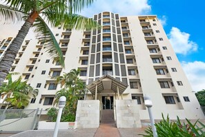 Un hôtel à plusieurs étages, doté d’une entrée principale, de balcons et offrant une vue sur un ciel dégagé.