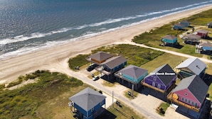 Vista aérea de uma área residencial costeira com casas perto da praia e do oceano.