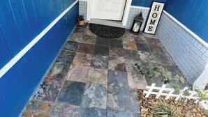 Ein blaues Gebäude mit einer weißen Tür, einem Schild mit der Aufschrift „Willkommen“ und einem Schild mit der Aufschrift 'HOME'.