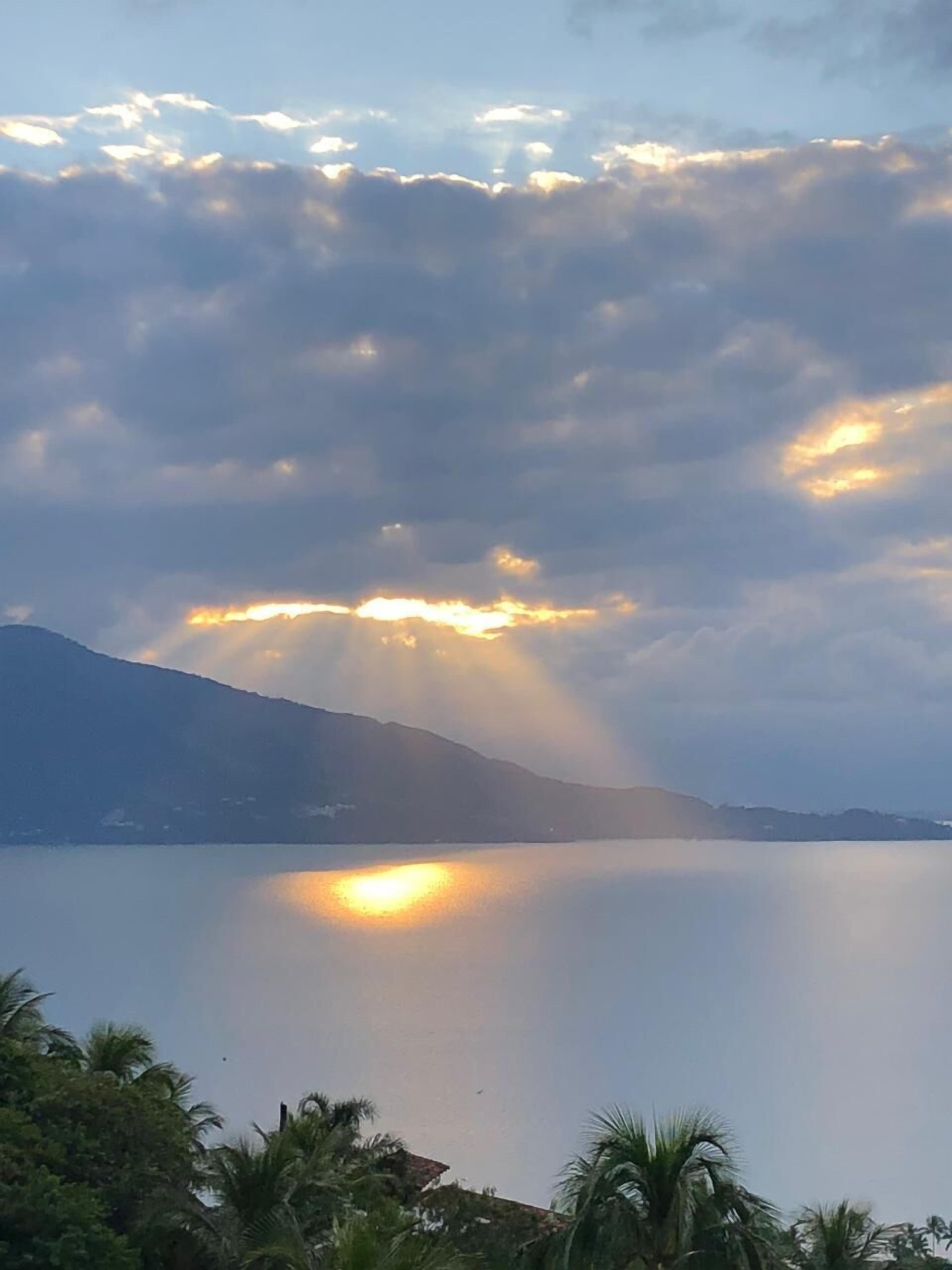 Een kalm meer met bergen op de achtergrond en een heldere lucht.