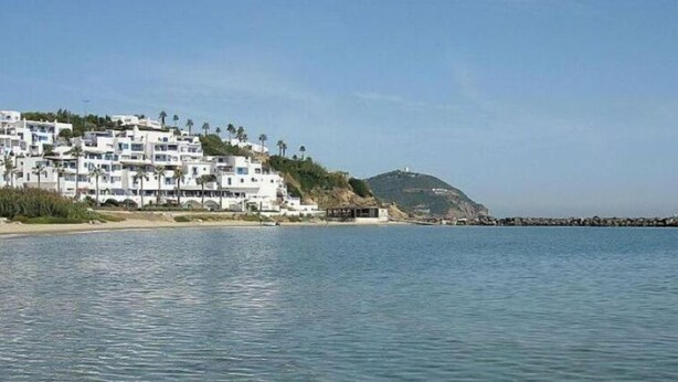 A coastal area with white buildings, a clear sky, and calm water. - Quiet spot in Cabo negro (Cabo Negro)