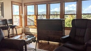 A room with large windows, a fireplace, and a view of the outdoors. - Spacious In-Town Condo | Pool | Hot Tub (Durango)