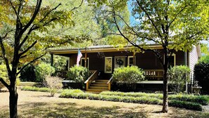 A two-story house with a porch, surrounded by trees and a well-maintained lawn. - Etowah River, Berry & Shorter College, Tennis, Trails-3 miles from Broad St. (Rome)