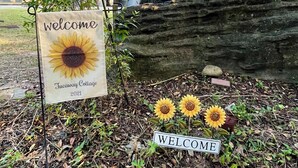 A welcome sign for Tucaway Cottage 2021, surrounded by trees and a rock formation. - Etowah River, Berry & Shorter College, Tennis, Trails-3 miles from Broad St. (Rome)
