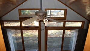 A ceiling fan in a room with large windows and wooden beams. - Sandy beach, quiet lake, great fishing & beautiful sunsets w/2 kayaks & gameroom (Cable)