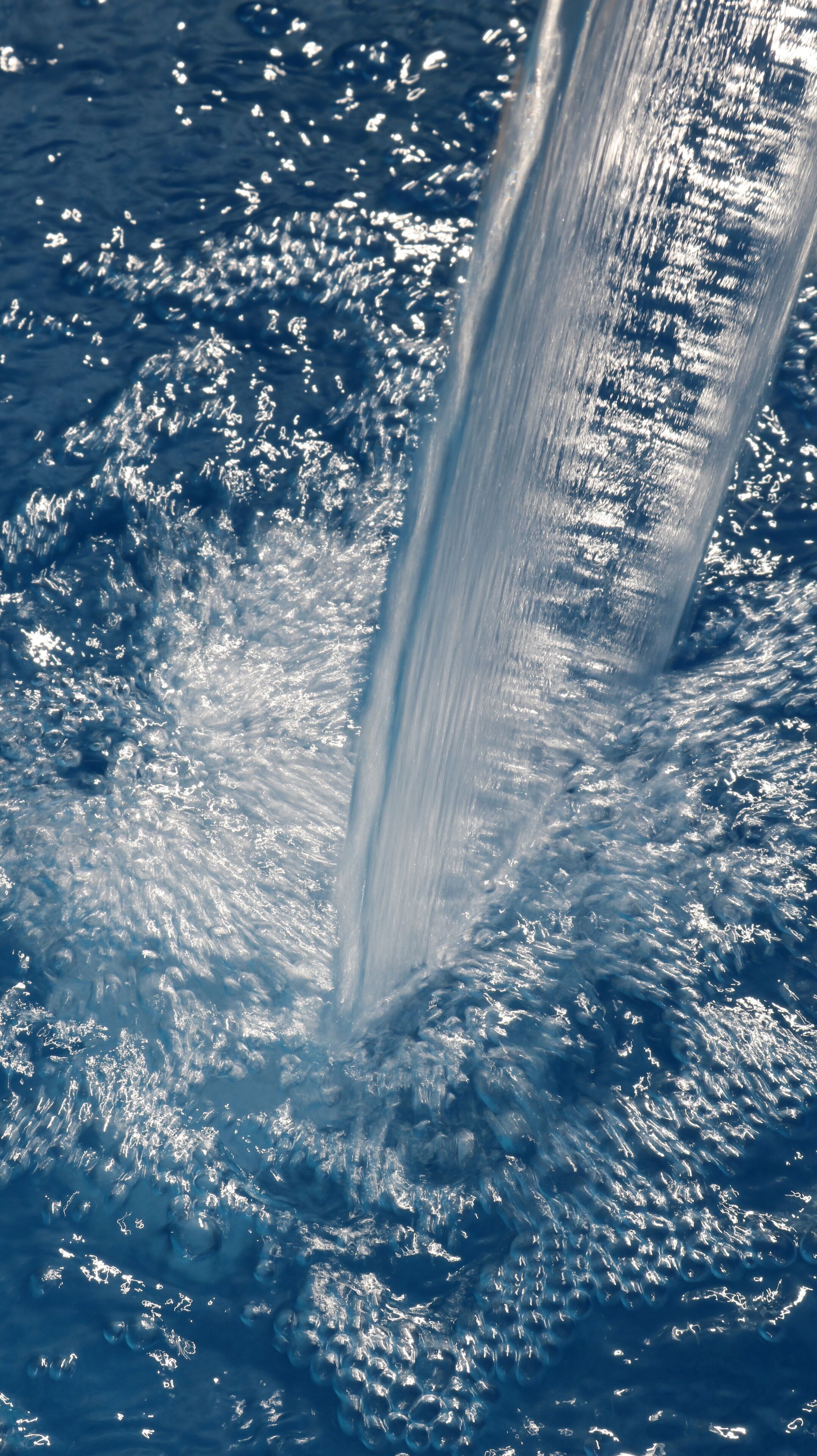 Un gros plan sur de l’eau, avec un courant clair et régulier qui s’écoule vers le bas.