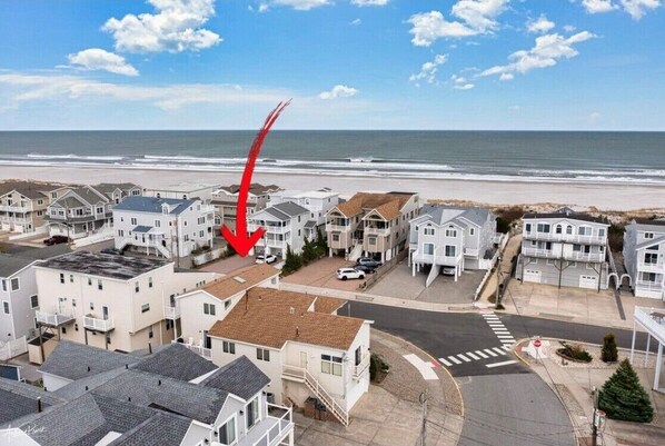 Houses line the beachfront, offering a serene coastal setting.