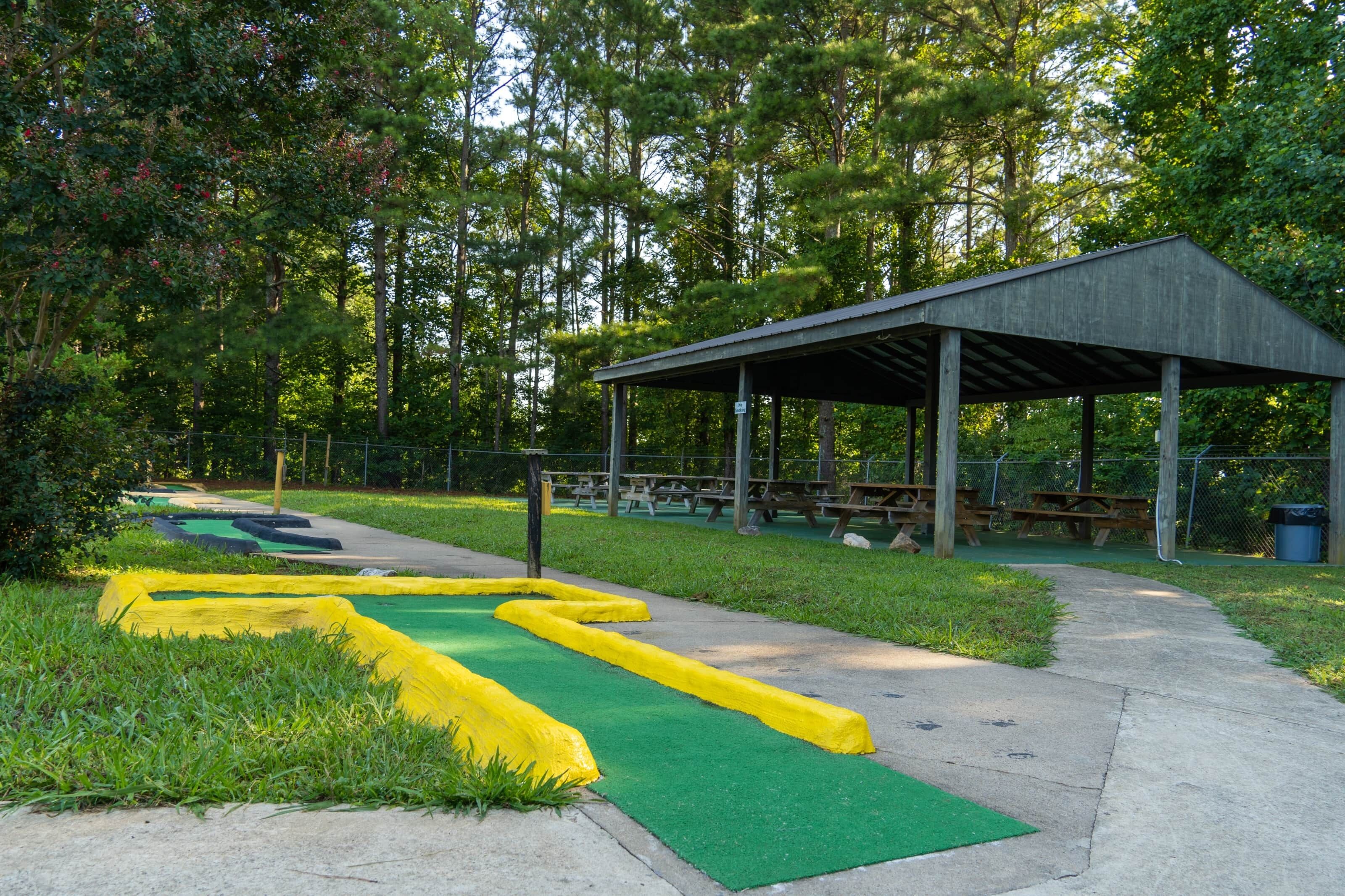 A covered picnic area with benches and a paved path.