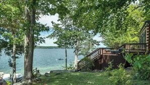 A lakeside cabin with a wooden deck and a boat dock. - Waterfront at Winnipesaukee with incredible views!! Boat Required (Alton)
