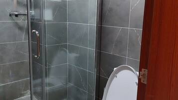 Bañera con ducha, toallas, jabón, papel higiénico