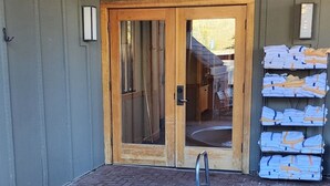 A spa area with a hot tub, wooden door, and towels stacked outside. - 1BD IN THE HEART OF RIVER RUN VILLAGE - 2 MIN. WALK TO GONDOLA (Keystone)