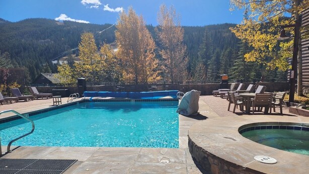 A swimming pool with a view of mountains, lounge chairs, and a hot tub. - 1BD IN THE HEART OF RIVER RUN VILLAGE - 2 MIN. WALK TO GONDOLA (Keystone)