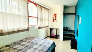 A small, compact room with a bed, a table, and a bunk bed. - HoM Balderas - Hostel (Mexico City)