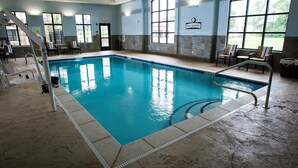 An indoor swimming pool with clear water, tiled walls, and a 'NO DIVING' sign.