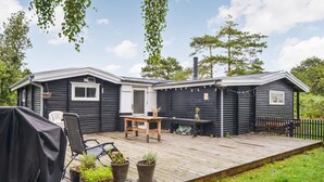 A cabin with a deck, a covered seating area, and potted plants. - 3 bedroom awesome home in Anholt (Anholt)