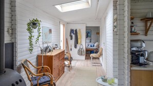 A cozy, compact living space with a kitchenette, a dining area, and a bedroom visible through an open door. - 3 bedroom awesome home in Anholt (Anholt)