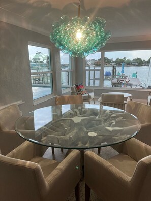 Relax in a serene waterfront setting with a stunning view, surrounded by a clean, contemporary design and comfortable seating.