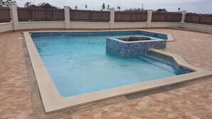 A rectangular swimming pool with a tiled edge and a built-in jacuzzi area. - Stunning townhouse in gated community -10 minutes from three beaches. (Mount Pleasant)