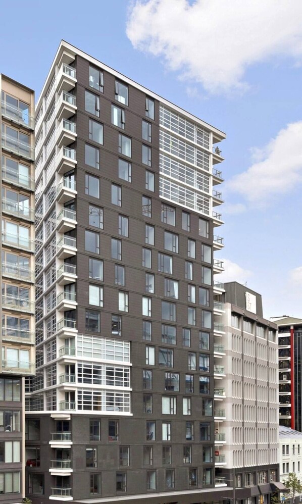 A multi-story building with a modern architectural design, featuring a mix of balconies and large windows.