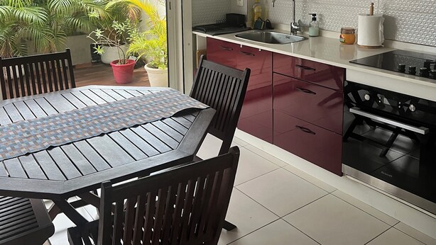 A modern kitchen with white cabinets, a gas stove, and a dining area with a table and chairs.