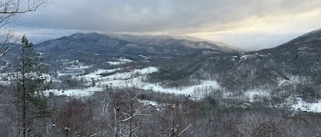 A mountainous landscape with snow-covered trees and a valley.