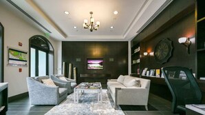 A modern lobby with a chandelier, sofas, a coffee table, and a TV screen. - Luxury Residence 3BR near 5th Ave & Beach (Naples)