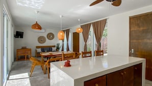Een moderne keuken met een groot kookeiland, houten meubels en hanglampen.