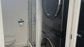 Een douche, handdoeken, zeep, shampoo